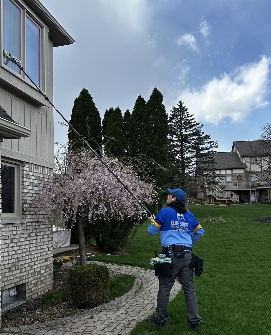Elite Shine technician cleaning second-story windows